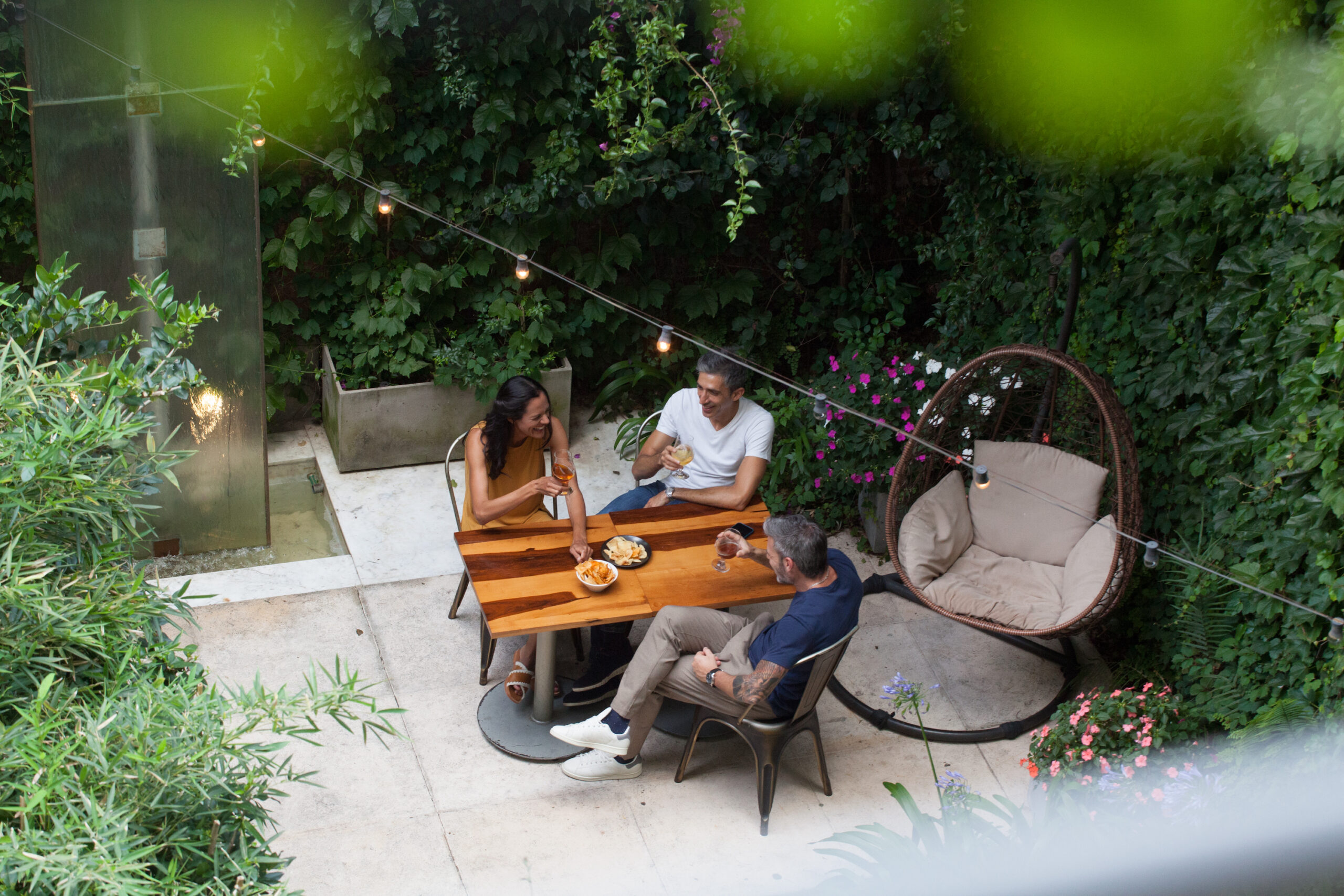 Group of friends enjoying drinks in the garden at Palo Santo Hotel